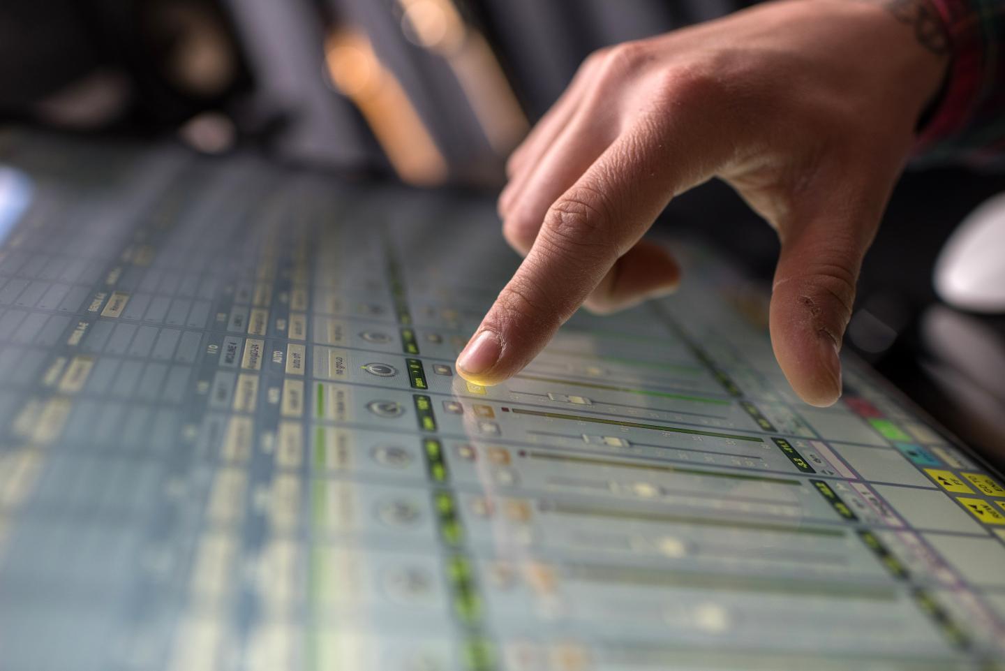Close-up of a man adjusting sound on digital sound mixer.