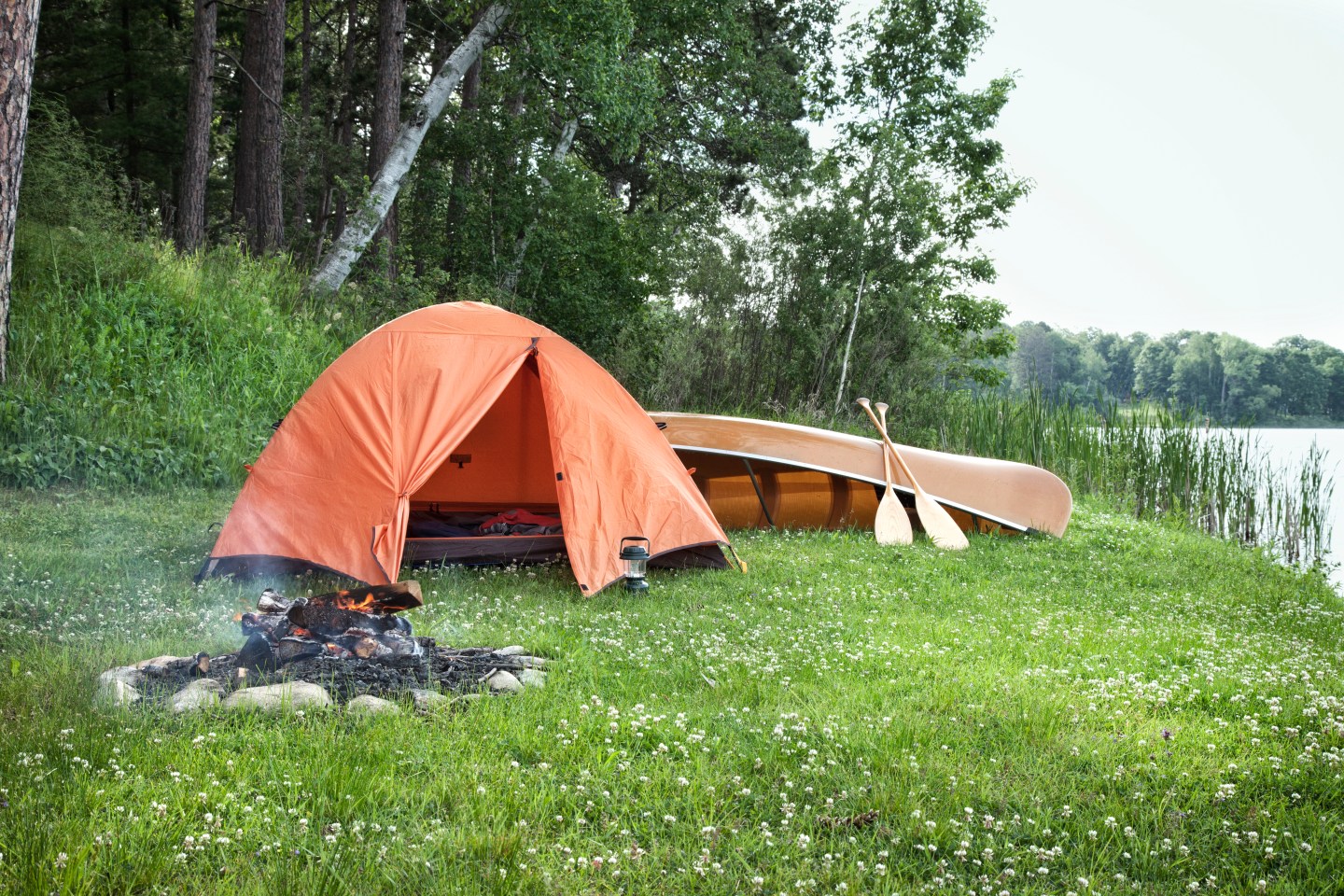 Orange Tent And Canoe On Grass By Lake