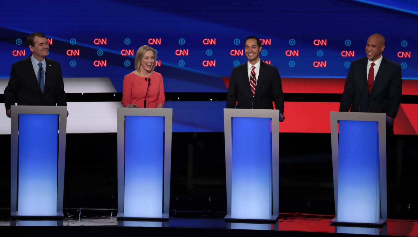 Democratic presidential candidates Sen. Michael Bennet (D-CO) (L-R), Sen. Kirsten Gillibrand (D-NY), former housing secretary Julian Castro, and Sen. Cory Booker (D-NJ) smile during the Democratic Presidential Debate at the Fox Theatre July 31, 2019 in Detroit, Michigan.