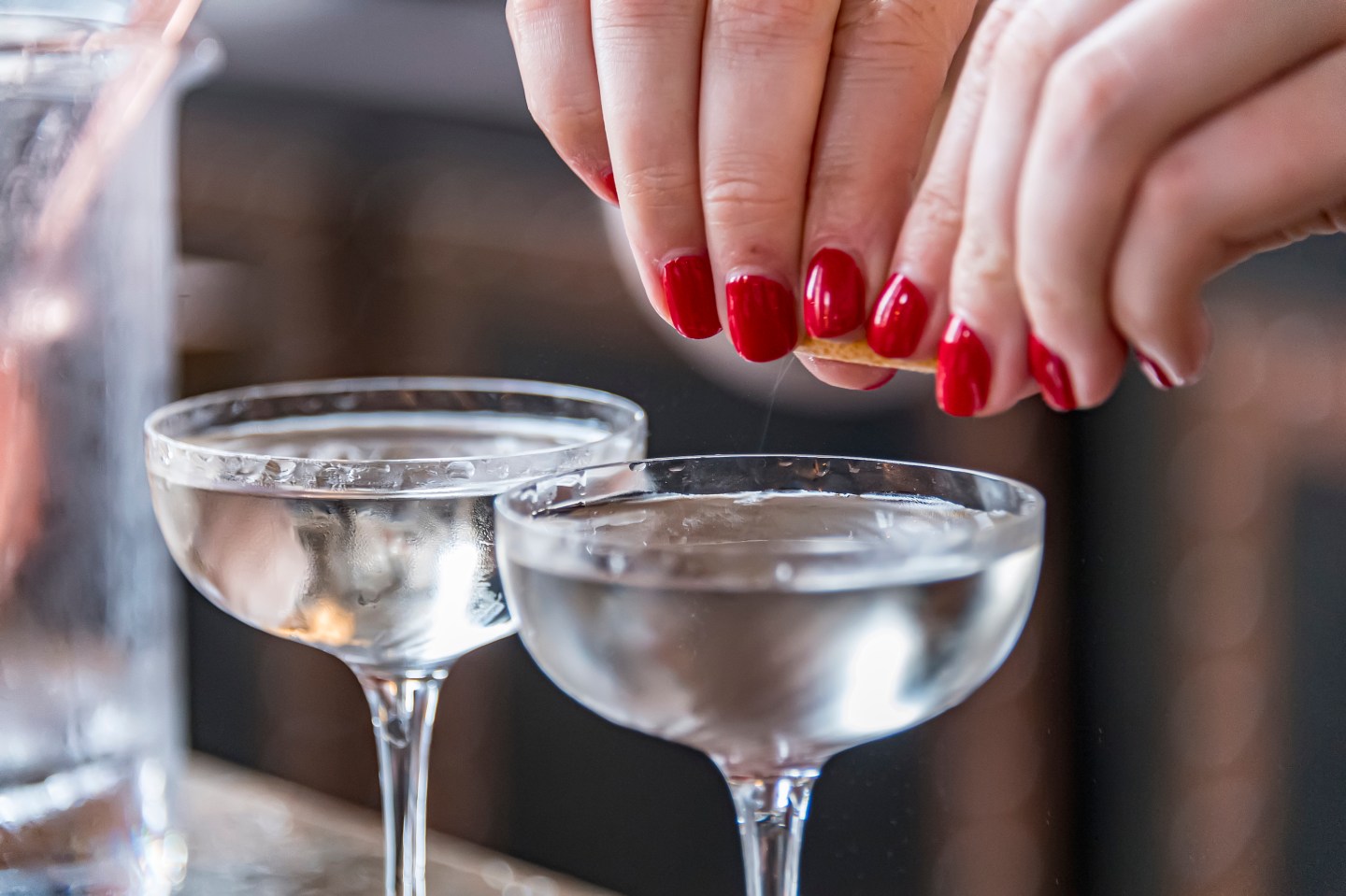 A bartender prepares a vodka martini.