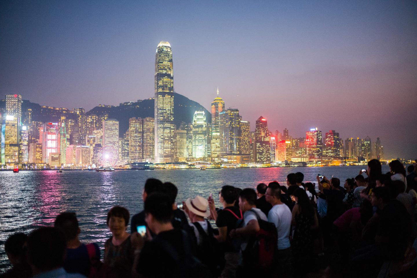 TOPSHOT - Tourists visit a Kowloon promenade along Victoria Harbour in Hong Kong on October 3, 2018, during China's 'Golden Week' holiday that runs from October 1 to 7. (Photo by Anthony WALLACE / AFP) (Photo credit should read ANTHONY WALLACE/AFP/Getty Images)