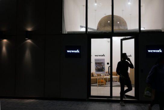 People exit the WeWork Cos. 32nd Milestone co-working space at night in Gurugram, India, on Monday, Feb. 18, 2019. The New York-based co-working giant WeWork Cos, which operates shared office spaces around the world, has attracted huge piles of investor money, which it uses to snap up office space in the largest cities on earth. Photographer: Ruhani Kaur/Bloomberg via Getty Images