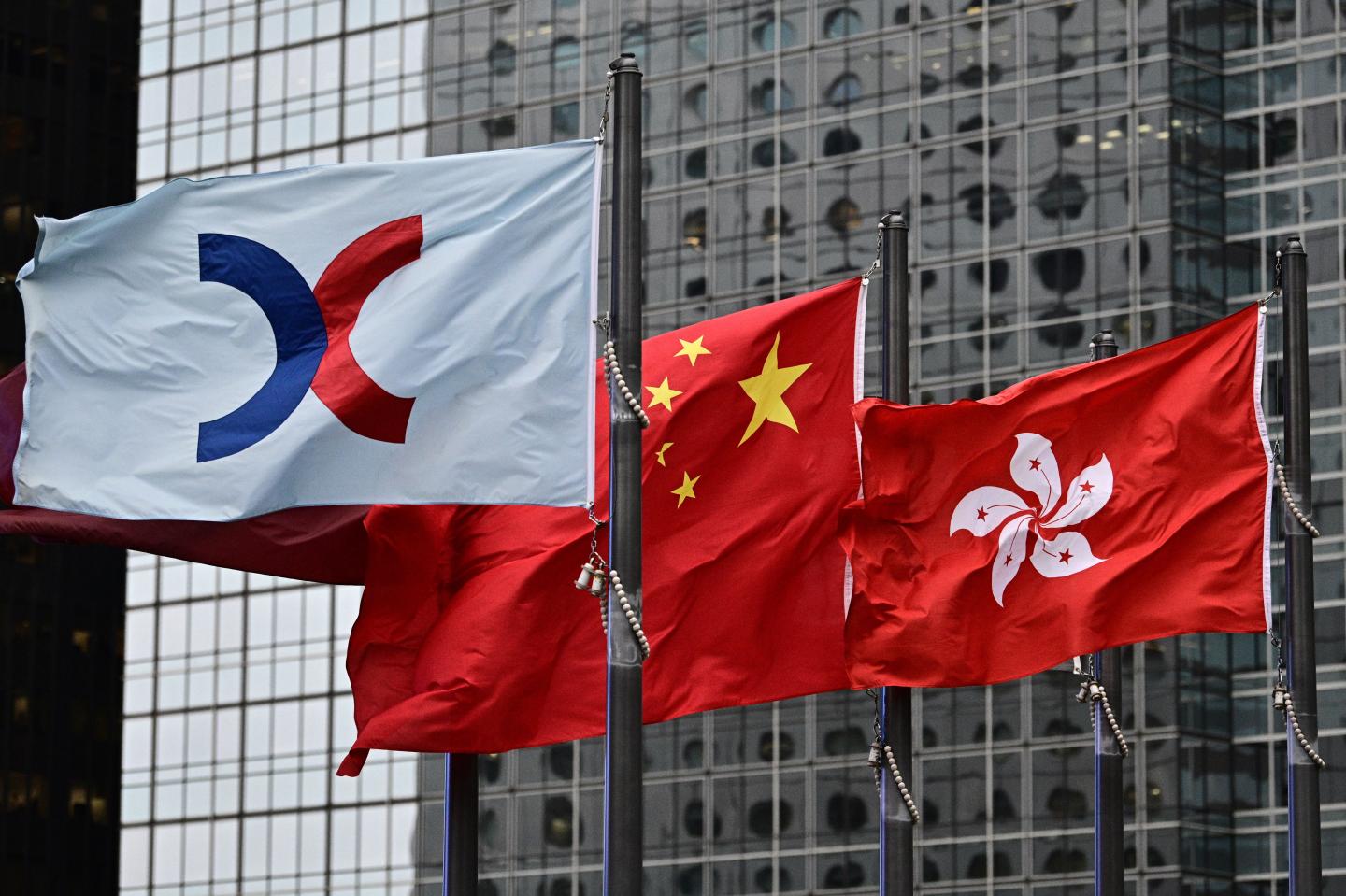 (L-R) The flags of the Hong Kong Stock Exchange, China and Hong Kong are seen flapping in the wind on May 6, 2019. (Photo by Anthony WALLACE / AFP) (Photo credit should read ANTHONY WALLACE/AFP/Getty Images)