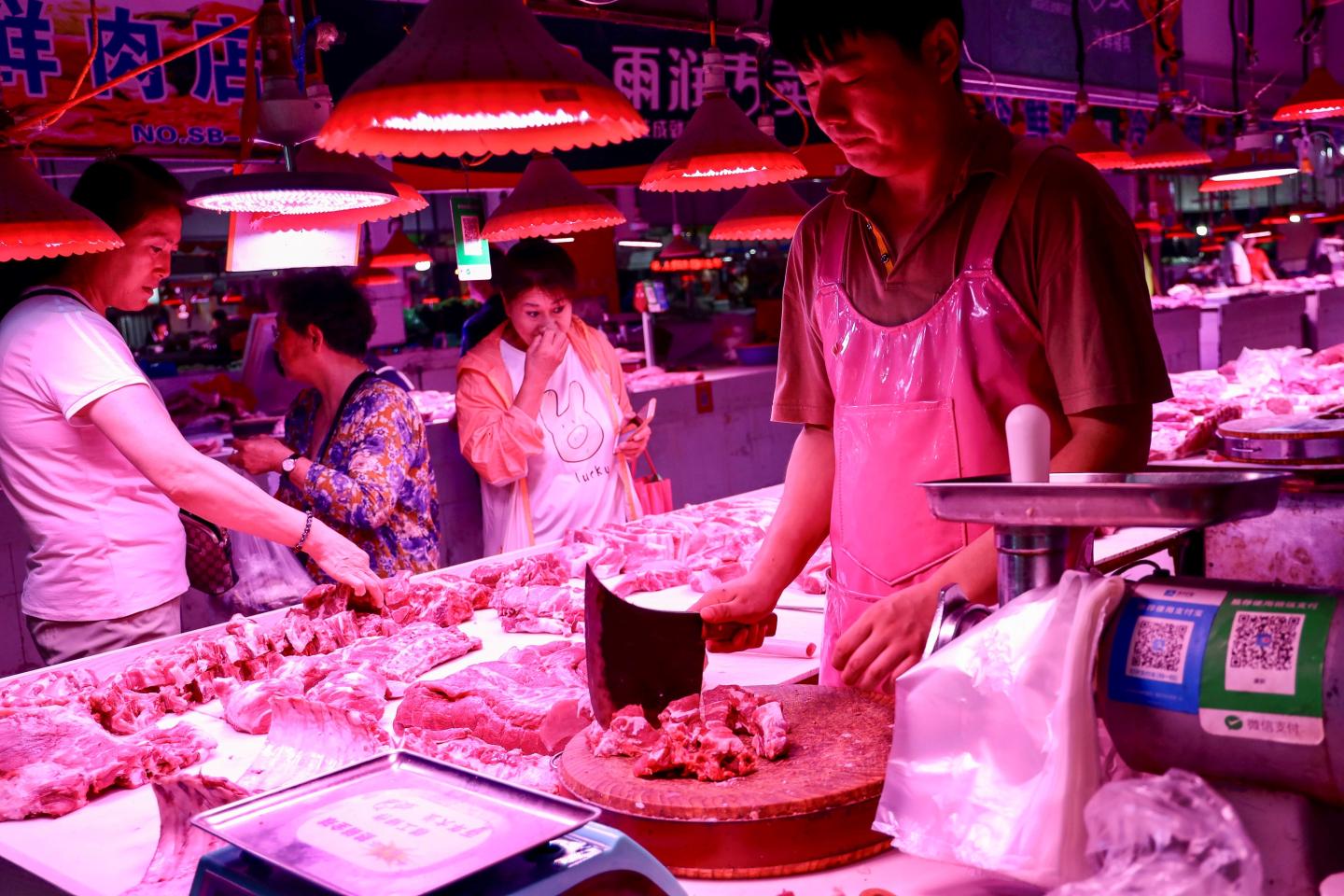 A butcher (R) chops pork meat at a market in Beijing on September 5, 2019. (Photo by STR / AFP) / China OUT (Photo credit should read STR/AFP/Getty Images)