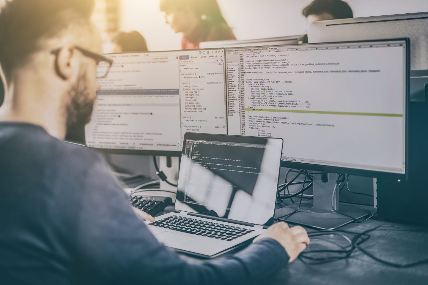 man sitting in front of computer screens