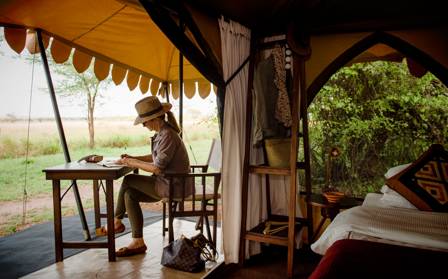 A woman writing in her journal after a safari tour with AdventureWomen, a female-run tour company running tours for female travelers.