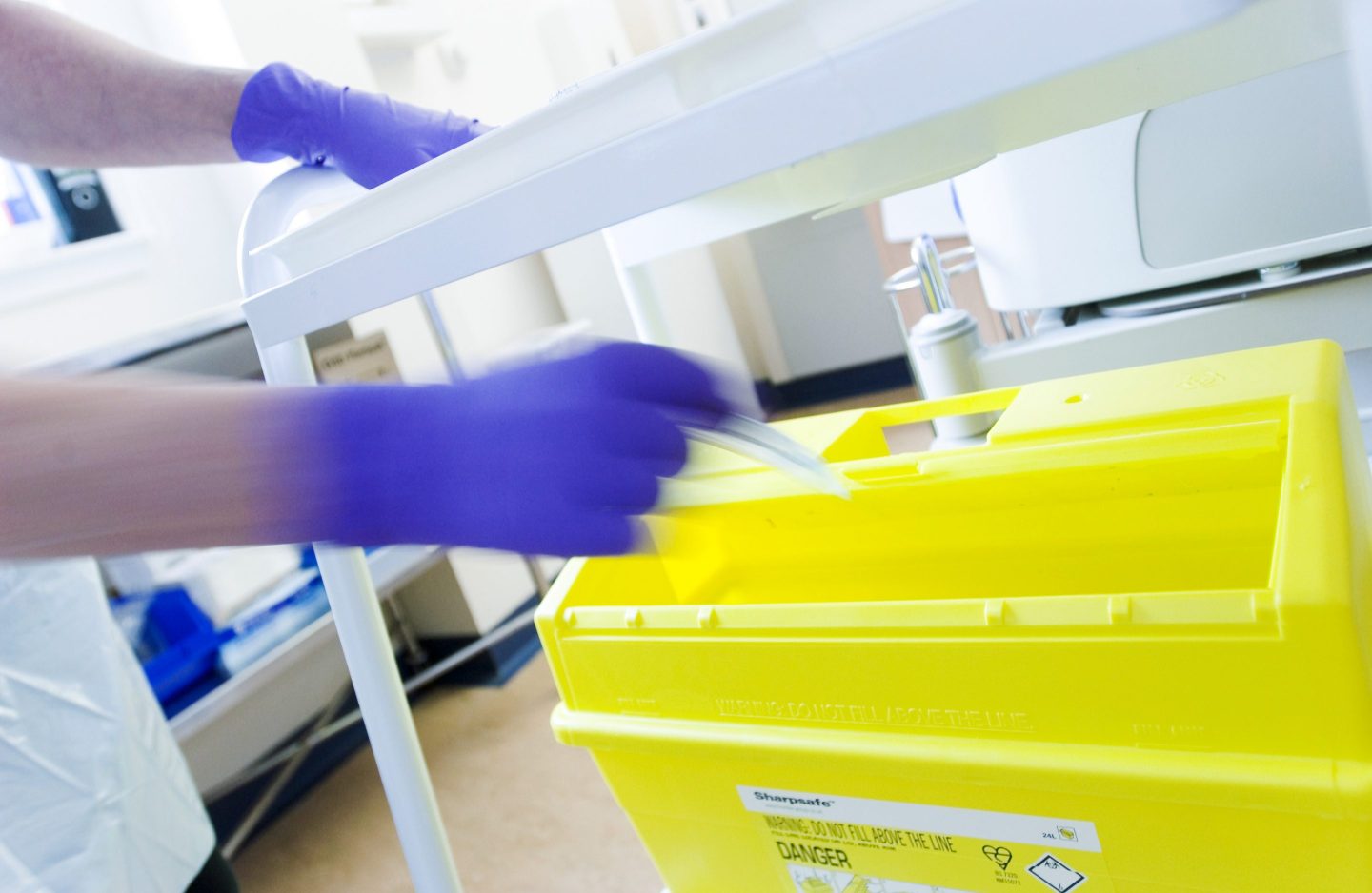 nurse throwing away needle into a bin