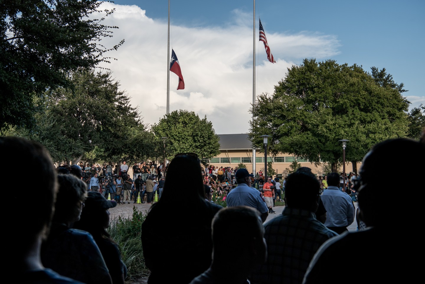 Flags fly at half mast over a prayer vigil at the University of Texas of the Permian Basin (UTPB) for the victims of a mass shooting, September 1, 2019 in Odessa, Texas.