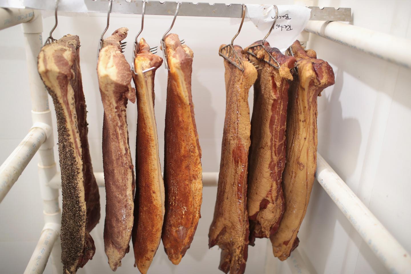 ELMA, IA - JULY 25: Workers smoke bacon while helping to process hogs at Elma Locker & Grocery on July 25, 2018 in Elma, Iowa. The locker custom butchers hogs and cattle and other livestock for area customers. According to the Iowa Pork Producers Association, Iowa is the number one pork producing state in the U.S. and the top state for pork exports. The state sends about 50 million hogs to market each year and its pork exports totaled more than $1.1 billion in 2017. Pork producers in Iowa are bracing for the impact a trade war with China and Mexico may have on their bottom line going forward. (Photo by Scott Olson/Getty Images)