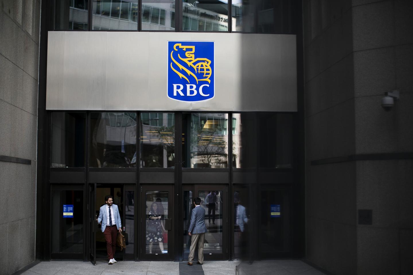 People enter and exit from the Royal Bank of Canada (RBC) headquarters in the financial district of Toronto, Ontario, Canada, on Thursday, July 25, 2019.
