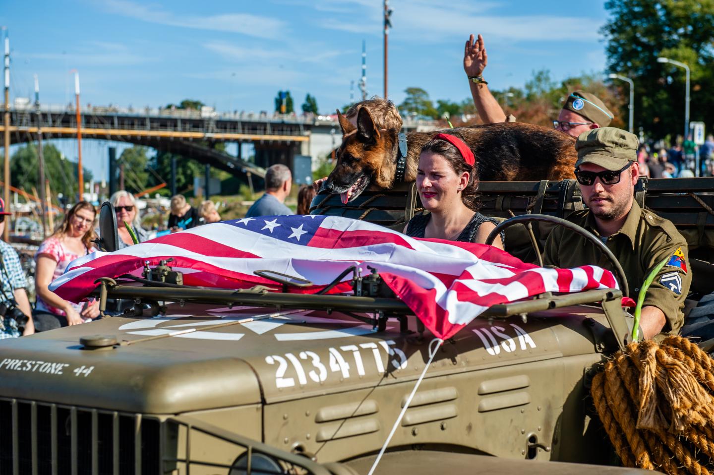 A military car with a big USA flag during the parade.