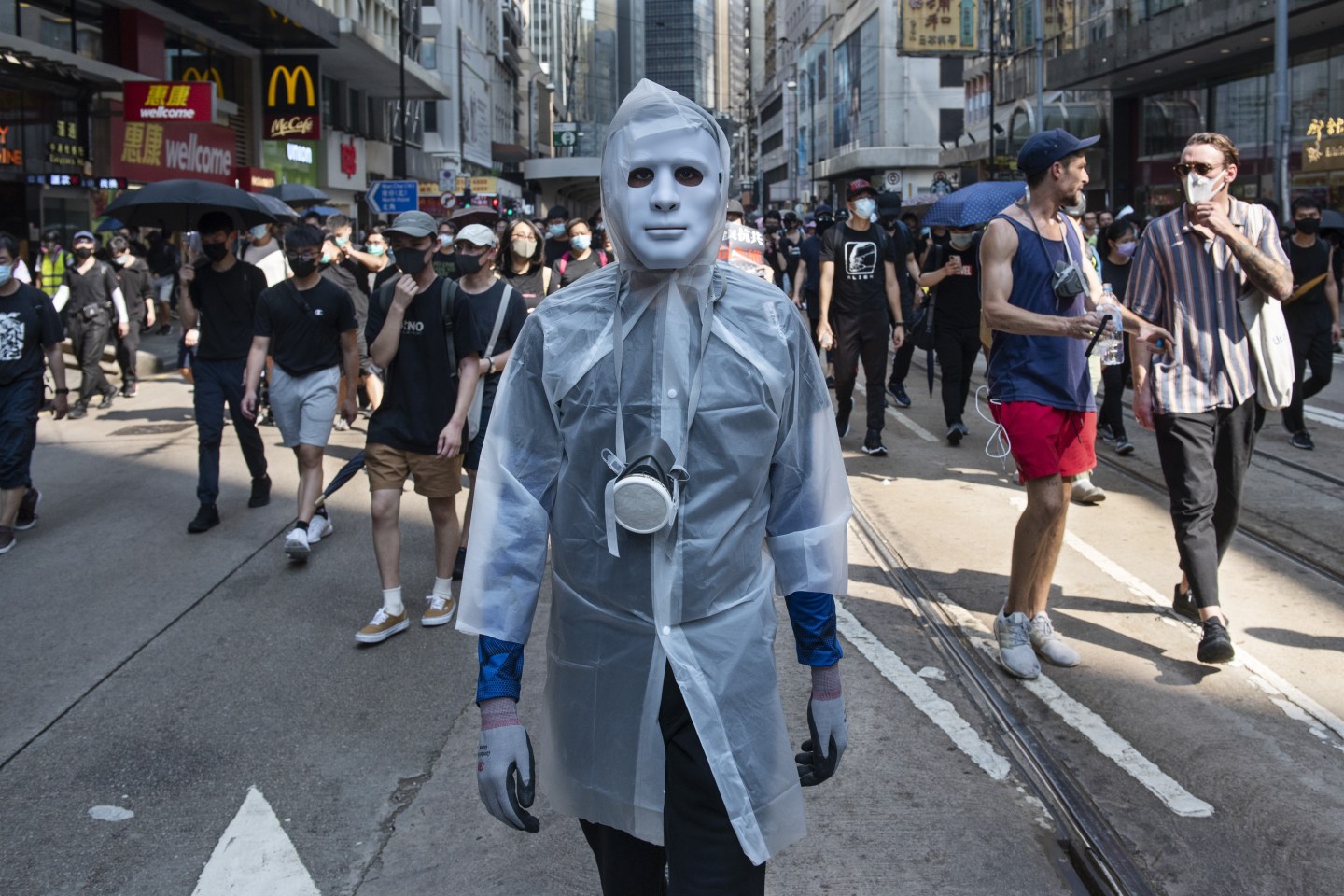 HONG KONG, CHINA - OCTOBER 02: A protester wears a white raining coat and mask during a rally as thousands of anti-china protesters marched and clashed with police in Hong Kong as the party celebrated its 70th year of rule on October 02, 2019. (Photo by Miguel Candela Poblacion/Anadolu Agency via Getty Images)