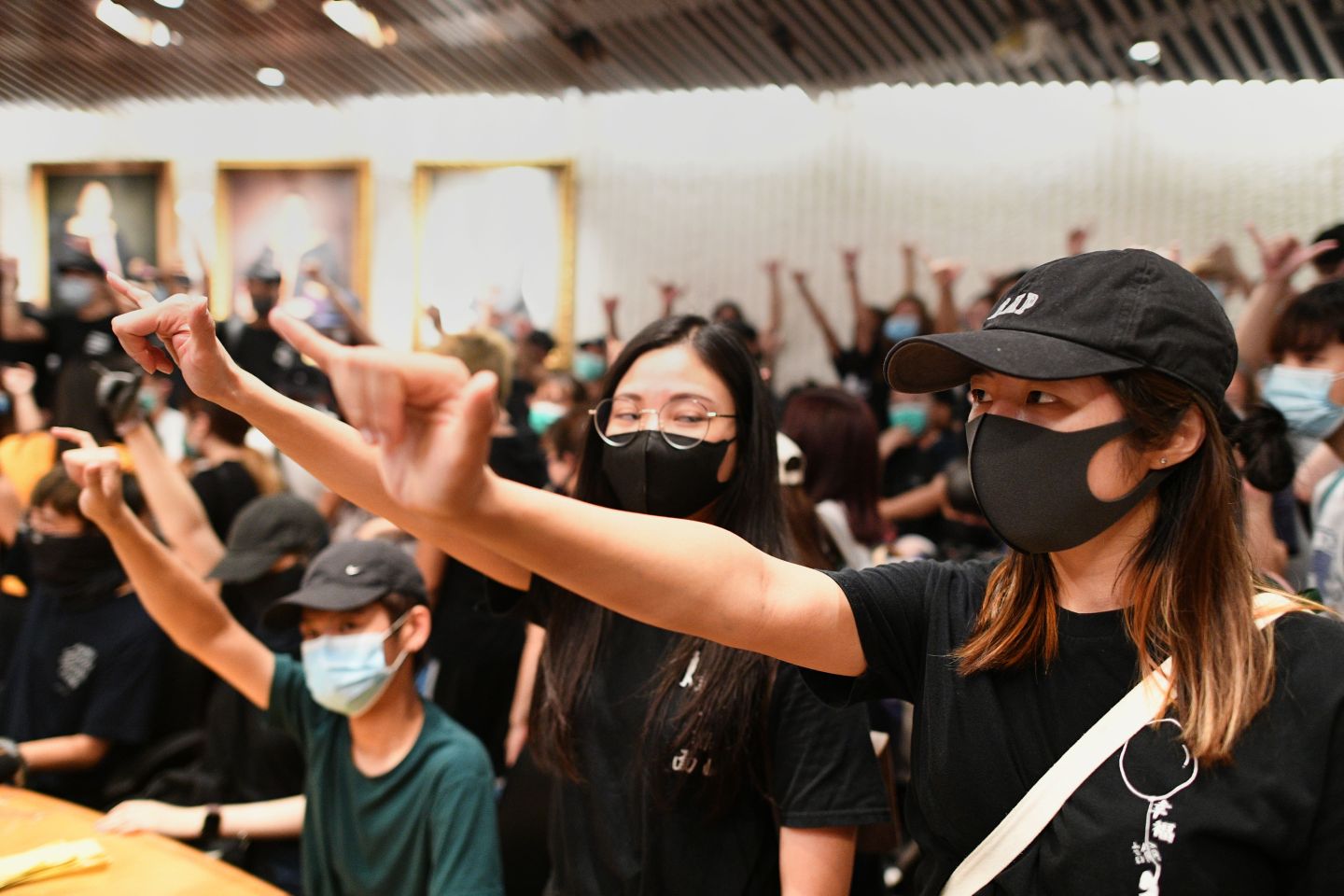 Student protesters gesture in a meeting room after forcing their way into the administrative offices at the Chinese University of Hong Kong (CUHK) to demand to speak to the school chairman in Hong Kong on October 3, 2019. - Anger continued to mount over the police shooting of a teenage protester on October 1 who attacked officers, in a dramatic escalation of the violent unrest that has engulfed the territory for months. (Photo by Mohd RASFAN / AFP) (Photo by MOHD RASFAN/AFP via Getty Images)