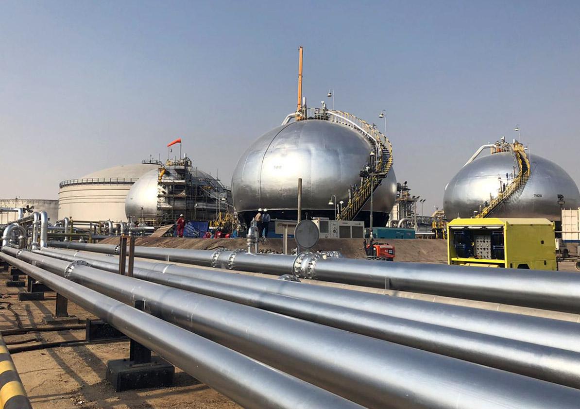 Three-phase spheroids stand behind pipelines at Saudi Aramco's crude oil processing facility, in Abqaiq, Saudi Arabia, on Saturday, Oct. 12, 2019. Aramco showed it has made significant progress in restoring damaged oil infrastructure to normal operation just a month after a devastating aerial attack halted production. Photographer: Dina Khrennikova/Bloomber