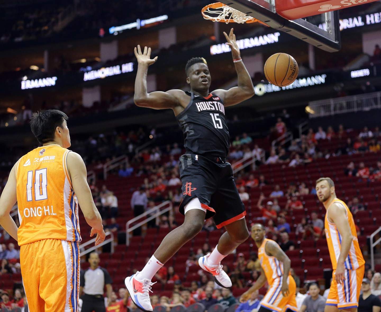 HOUSTON, TEXAS - SEPTEMBER 30: Clint Capela #15 of the Houston Rockets dunks as Donatas Motiejunas #12 of the Shanghai Sharks and Dong Hanlin #10 look on during the second quarter at Toyota Center on September 30, 2019 in Houston, Texas. NOTE TO USER: User expressly acknowledges and agrees that, by downloading and/or using this photograph, user is consenting to the terms and conditions of the Getty Images License Agreement. (Photo by Bob Levey/Getty Images)