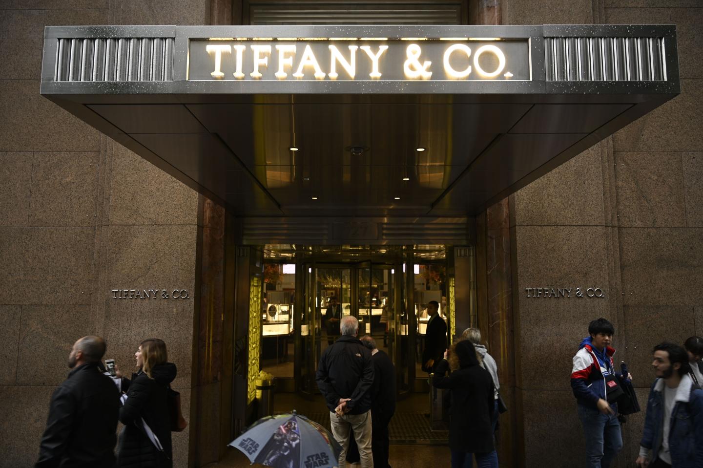 People walk past the headquarters of luxury jewelry and specialty retailer Tiffany &amp; Co on 5th Avenue in Manhattan on October 27, 2019 in New York City. - LVMH, the French owner of Louis Vuitton, is exploring a takeover of Tiffany &amp; Co to expand in the US jewelry market, according to reports. (Photo by Johannes EISELE / AFP) (Photo by JOHANNES EISELE/AFP via Getty Images)