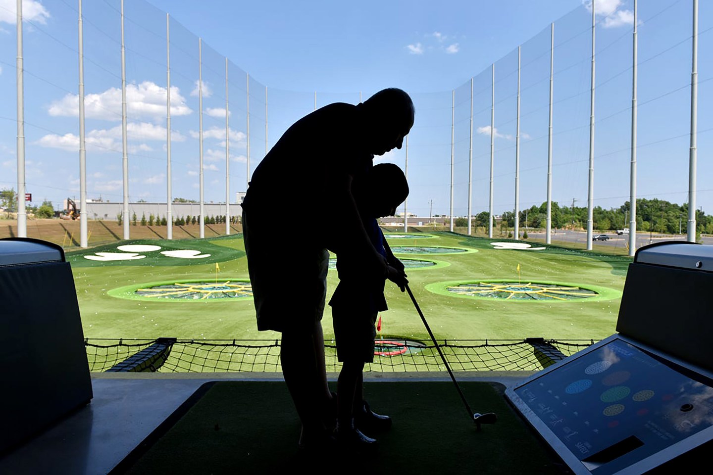 Ashan Hendi helps his son Ali hit a golf ball at Topgolf Greenville.0719 Up Gsp Topgolf 01