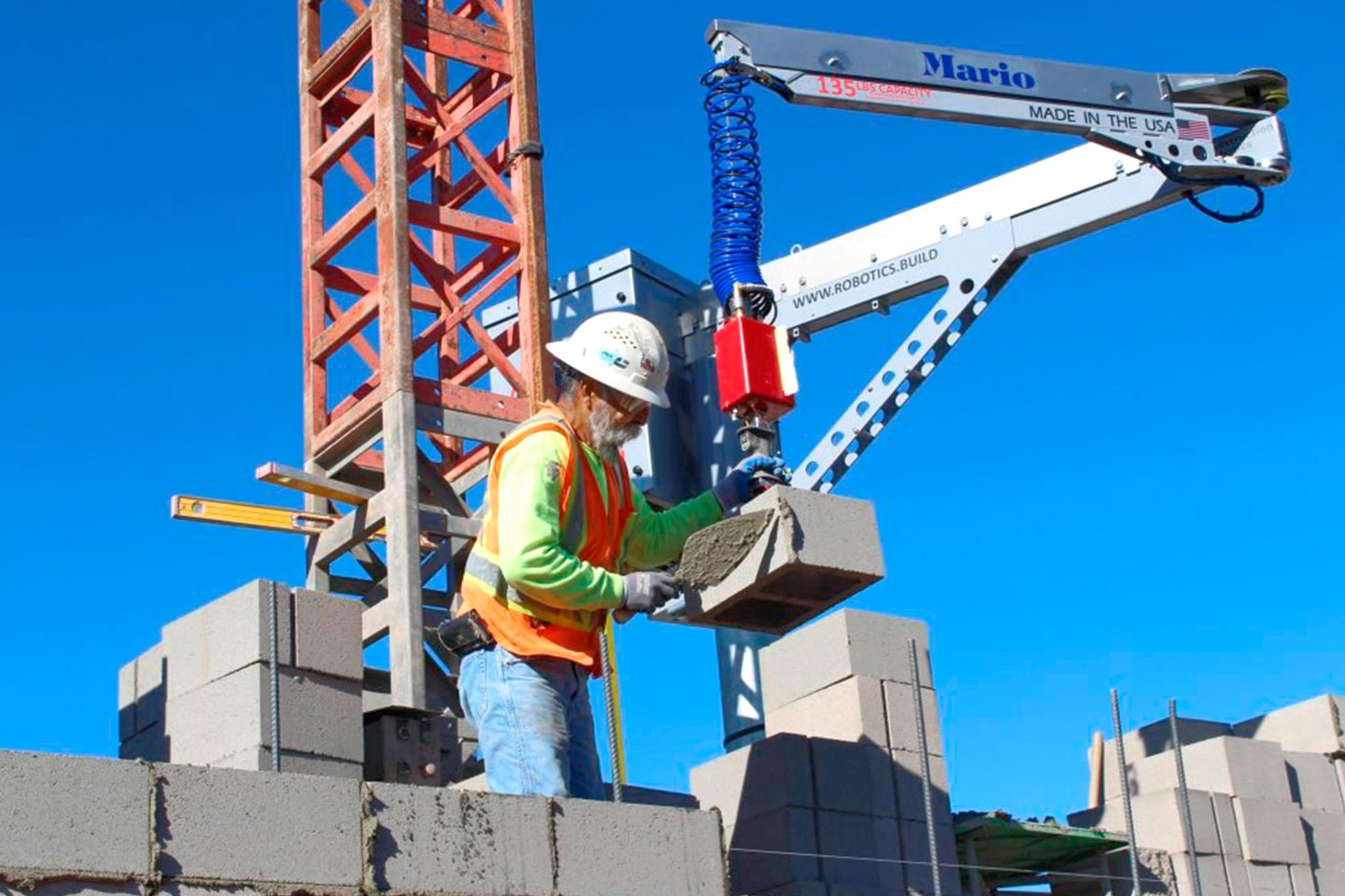A robot called MULE, from Construction Robotics, lifts heavy concrete blocks.