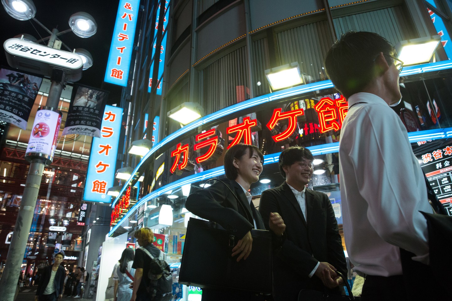 SHIBUYA DISTRICT, TOKYO, JAPAN - 2019/10/01: Japanese office workers walk by a Karaoke bar at Shibuya district in Tokyo. (Photo by Stanislav Kogiku/SOPA Images/LightRocket via Getty Images)