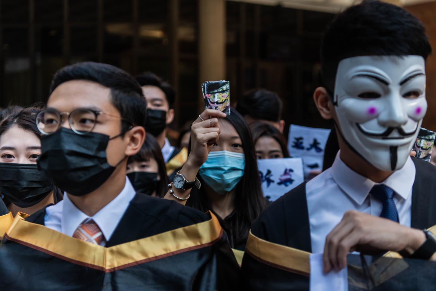 HONG KONG, CHINA - NOVEMBER 05: University students wearing Guy Fawkes masks march before their graduation ceremony at the Hong Kong Polytechnic University on November 05, 2019 in Hong Kong, China. Hong Kong slipped into a technical recession on Thursday after anti-government demonstrations stretched into its fifth month while protesters continue to call for Hong Kong's Chief Executive Carrie Lam to meet their remaining demands since the controversial extradition bill was withdrawn, which includes an independent inquiry into police brutality, the retraction of the word "riot" to describe the rallies, and genuine universal suffrage. (Photo by Billy H.C. Kwok/Getty Images)