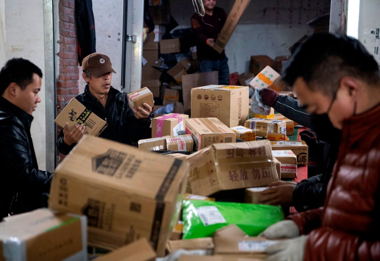 Workers sort out packages at a delivery company warehouse to be delivered to customers during "Singles' Day" -- the world's biggest 24-hour shopping event -- in Beijing on November 11, 2019. - Chinese consumers closed in on a new spending record November 11 during the annual "Singles' Day" frenzy, the world's biggest 24-hour shopping event, which kicked off this year with a glitzy show by US megastar Taylor Swift. (Photo by NOEL CELIS / AFP) (Photo by NOEL CELIS/AFP via Getty Images)