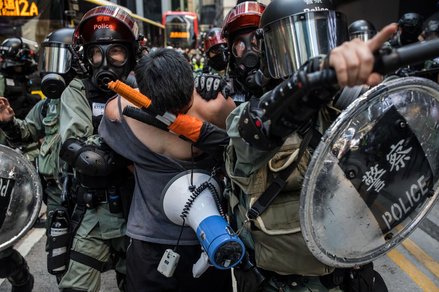 A man is led away by the police during a protest in the Central district of Hong Kong, China, on Monday, Nov. 11, 2019. A Hong Kong protester was in critical condition after being shot by a police officer, as the financial hub reeled from citywide efforts to disrupt the work week amid worsening political unrest. Photographer: Nicole Tung/Bloomberg via Getty Images