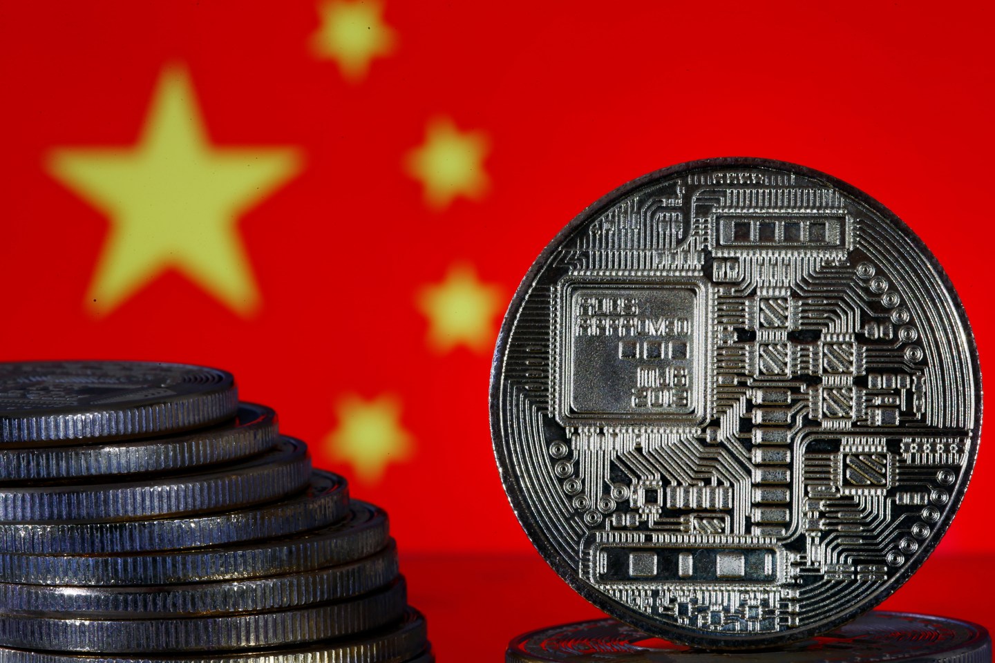 PARIS, FRANCE - OCTOBER 17: In this photo illustration, a visual representation of digital cryptocurrency coins sit on display in front of a Chinese flag on October 17, 2019 in Paris, France. China is preparing to launch its sovereign cryptocurrency with 5 banks, Alibaba and Tencent. Chinese authorities are stepping up preparations for their own virtual currency as Facebook promises to revolutionize payments with its virtual currency called 'libra'. No date has been set, but media speculate on a launch from November 11, 'feast of singles' the day of shopping frenzy online in China. (Photo by Chesnot/Getty Images)