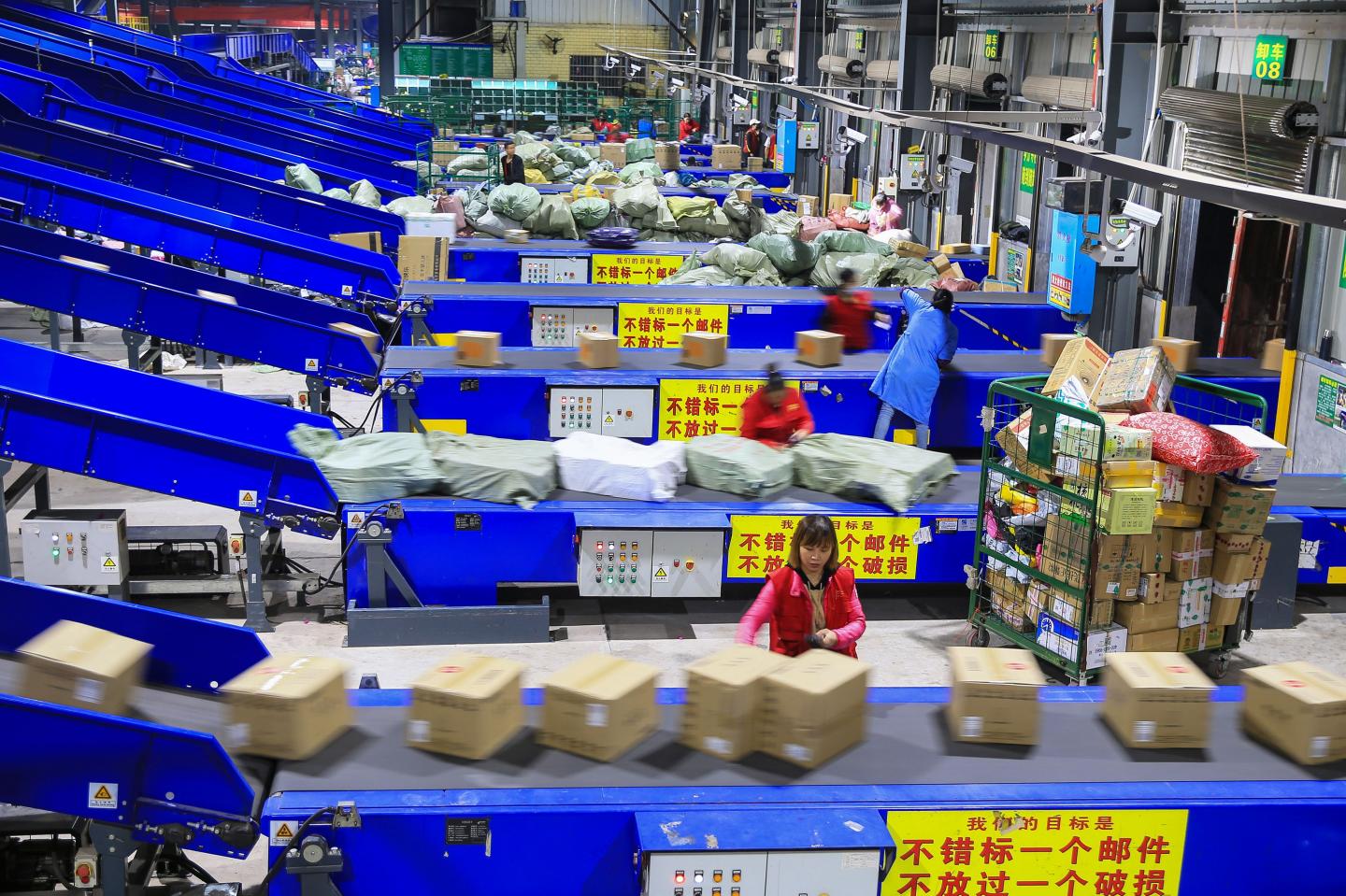 Workers sort out packages at a delivery company a day after "Singles' Day" -- the world's biggest 24-hour shopping event -- in Hengyang in China's central Hunan province early on November 12, 2019. - Chinese shoppers set new records for spending during the annual "Singles' Day" buying spree despite an economic slowdown and worries over the US trade war, with state media calling it a sign of China's rising economic strength. E-commerce giant Alibaba said consumers spent $38.3 billion on its platforms on November 11 during the world's biggest 24-hour shopping event, up 26 percent from the previous all-time high mark set last year. (Photo by STR / AFP) / China OUT (Photo by STR/AFP via Getty Images)