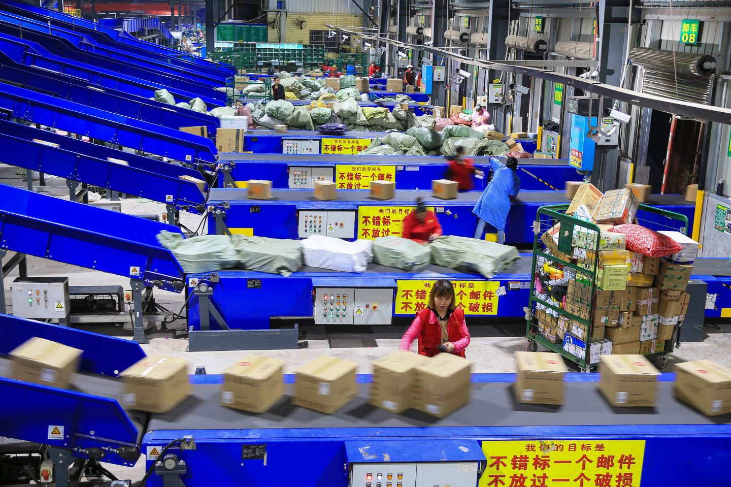 Workers sort out packages at a delivery company a day after "Singles' Day" -- the world's biggest 24-hour shopping event -- in Hengyang in China's central Hunan province early on November 12, 2019. - Chinese shoppers set new records for spending during the annual "Singles' Day" buying spree despite an economic slowdown and worries over the US trade war, with state media calling it a sign of China's rising economic strength. E-commerce giant Alibaba said consumers spent $38.3 billion on its platforms on November 11 during the world's biggest 24-hour shopping event, up 26 percent from the previous all-time high mark set last year. (Photo by STR / AFP) / China OUT (Photo by STR/AFP via Getty Images)