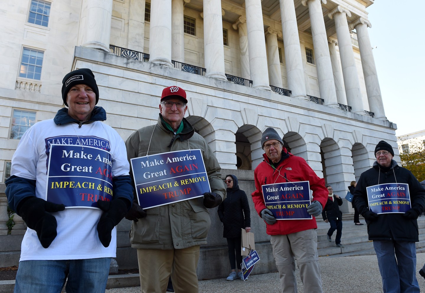 Pro-impeachment protesters hold placards outside of the Longworth building on Capitol Hill where the House Intelligence Committee is holding public impeachment hearings into President Donald Trump's actions regarding U.S.-Ukraine policy. Olivier Douliery/AFP/Getty Images