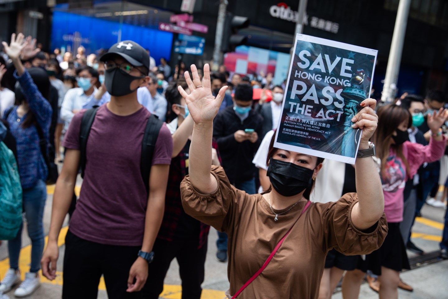 A demonstrator gestures "Five Demands" as she holds a placard during a protest in the Central district of Hong Kong, China, on Nov. 14, 2019. Hong Kong has seen many violent days since the unrest began in June, but the disruption this week has taken things to a new level -- and fears are growing as to what may come next. Photographer: Kyle Lam/Bloomberg via Getty Images