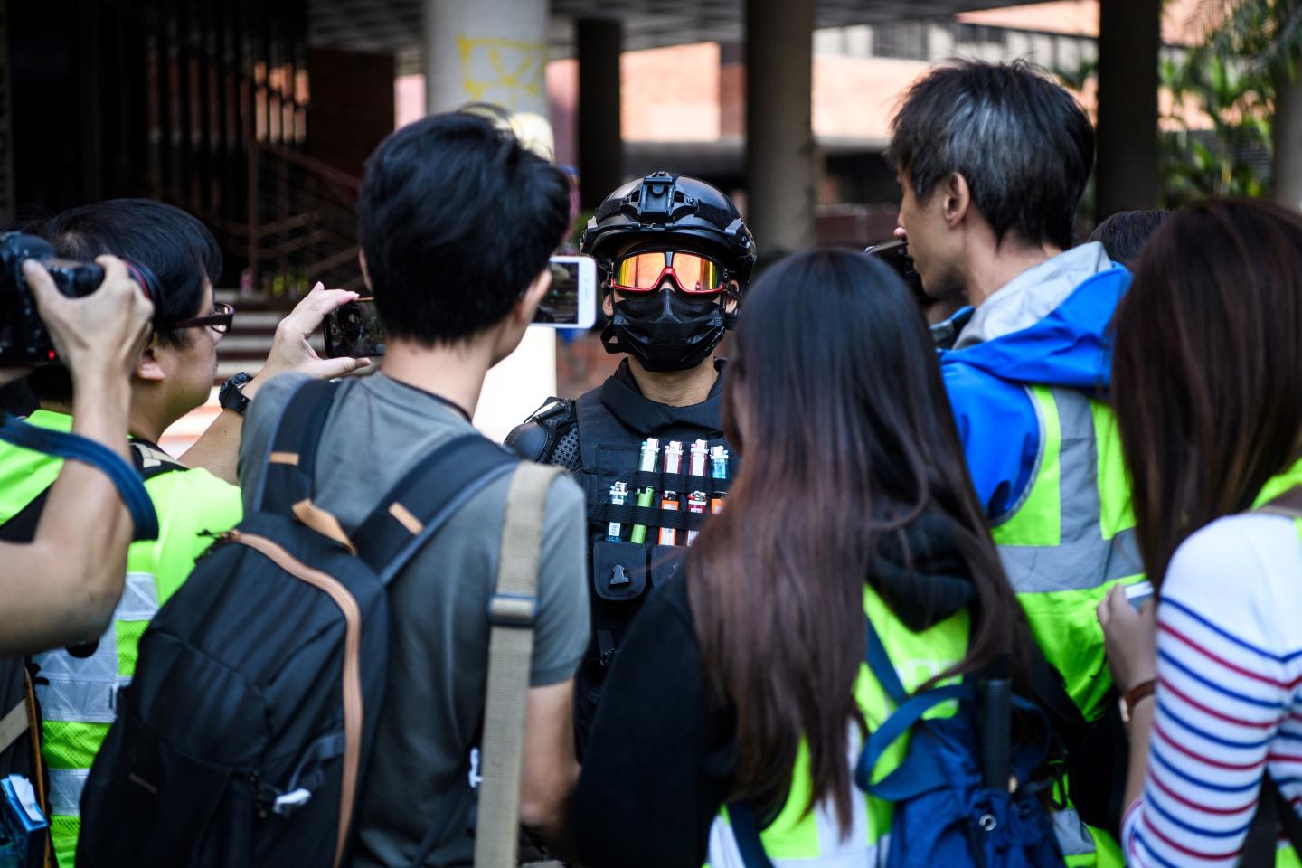 TOPSHOT - A male protester (C), who gave his age as 16, speaks to the media at the campus of the Hong Kong Polytechnic University in the Hung Hom district of Hong Kong on November 20, 2019. - Dozens of pro-democracy protesters remained holed up inside the besieged Hong Kong university campus for a fourth straight day on November 20 as supporters took up online calls to disrupt the citys train network in a bid to distract police. (Photo by Anthony WALLACE / AFP) (Photo by ANTHONY WALLACE/AFP via Getty Images)