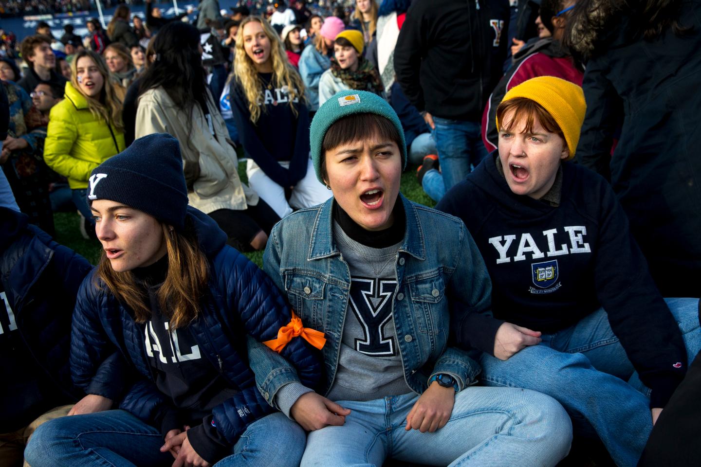 From left, Yale senior Nadia Grisaru, senior Sarah Adams and sophomore Lillian Burton protest during the halftime of the college football game between Harvard and Yale at the Yale Bowl in New Haven, CT on Saturday, Nov. 23, 2019.