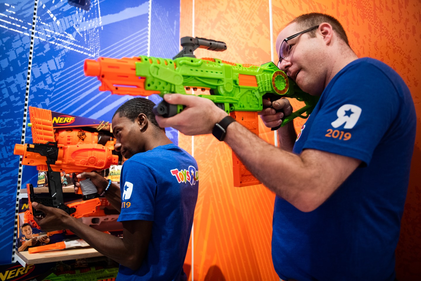 Two employees demonstrate Hasbro Inc. Nerf brand blasters at a Toys "R" Us Inc. store in Paramus, New Jersey.