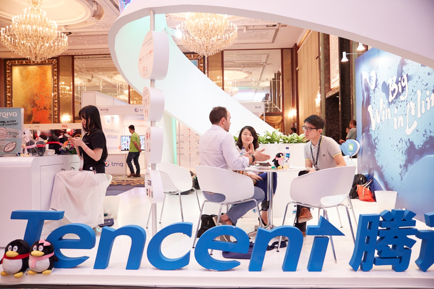 SINGAPORE - MARCH 15: Visitors and exhibitors network at the Tencent booth during the Sportel Asia Conference on March 15, 2016 in Singapore. (Photo by Sean Lee/Getty Images for Sportel)