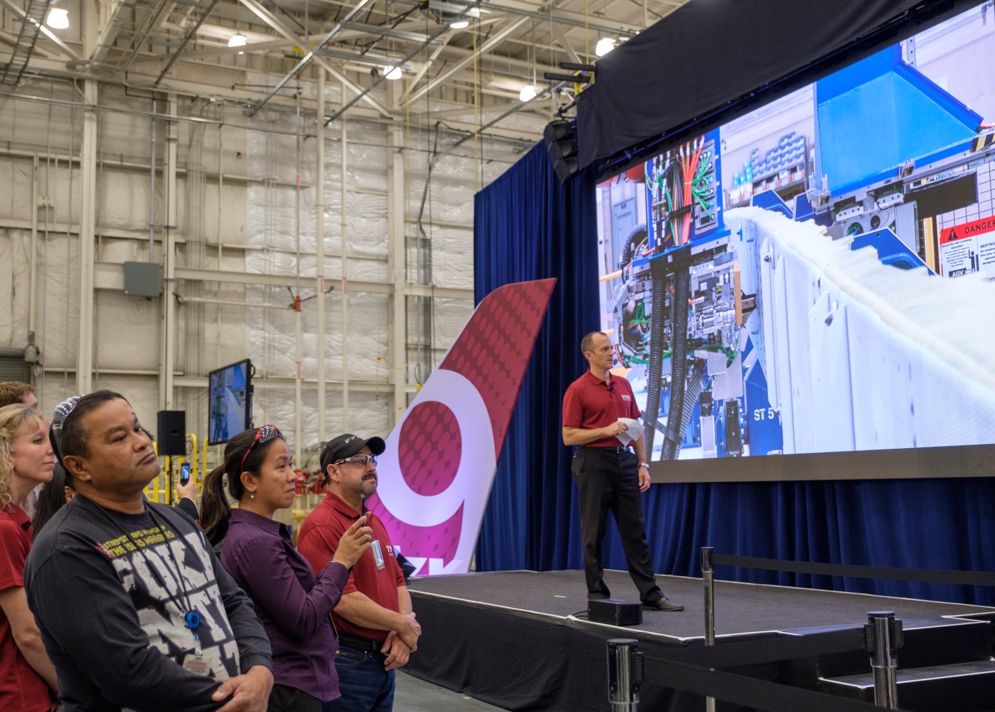 EVERETT, WA - OCTOBER 23: Boeing employees and Jason Clark, Boeing vice president of 777/777X Operations, watch as a wing spar assembly robot, on scree, begins production on the first Boing 777X airplane, on October 23, 2017 in Everett, Washington. The 777X jetliner, which will feature many of the fuel-saving innovation of the Boeing 787. (Photo by Stephen Brashear/Getty Images)