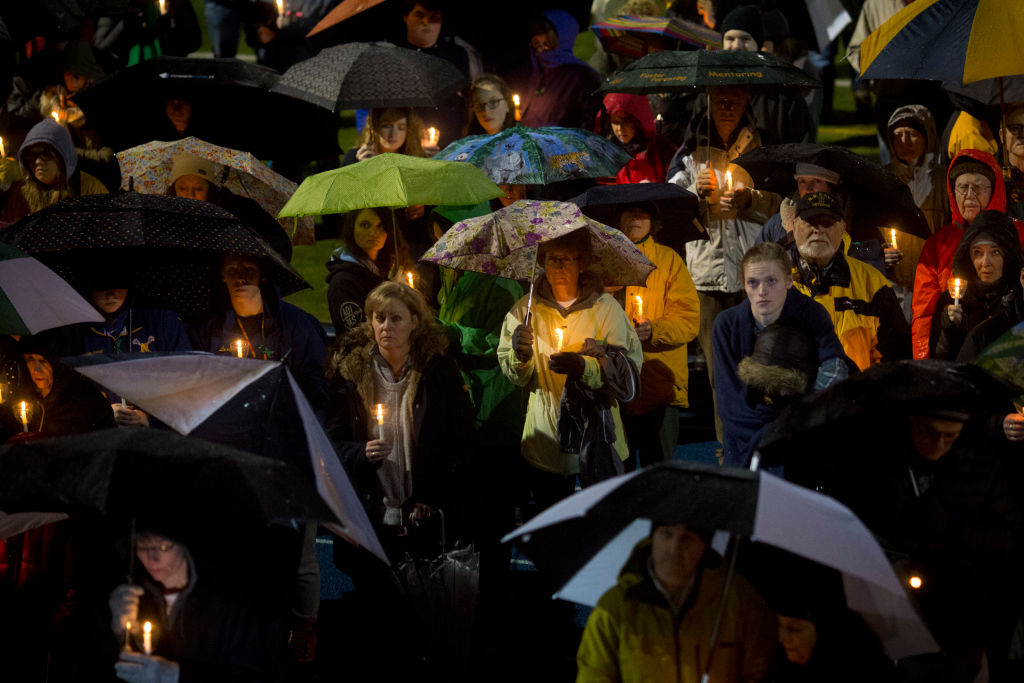 Mourners listen while names are read aloud during a community vigil in February 2019 at Newtown High School for the victims of a mass shooting at Marjory Stoneman Douglas High School in Parkland, Florida. Newtown is home to Sandy Hook Elementary School, where 26 people, 20 of them children, were killed in a mass shooting in 2012. Drew Angerer—Getty Images