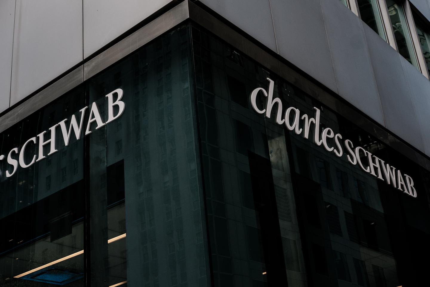 Charles Schwab Corp. signage is displayed outside an office building in New York, U.S., on Thursday, April 12, 2018. Charles Schwab Corp. reported earnings per share for the first quarter that beat the average analyst estimate, with 443,000 new accounts, the highest quarterly level in 18 years, chief executive officer Walt Bettinger said in a statement. Photographer: Christopher Lee/Bloomberg via Getty Images