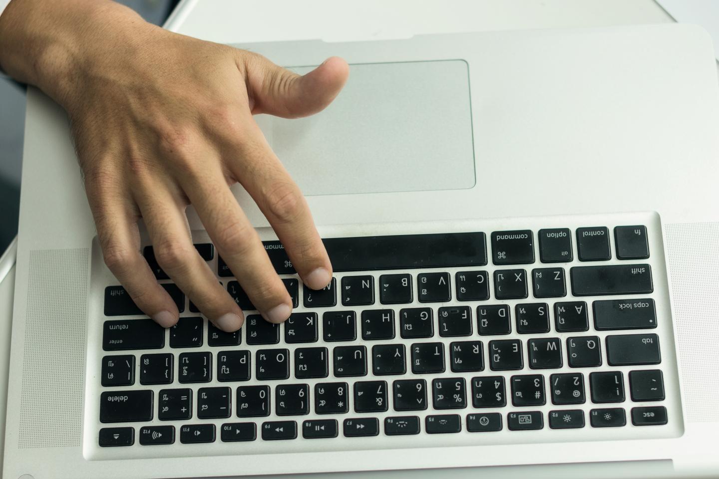 Close up of doctor working on laptop computer.