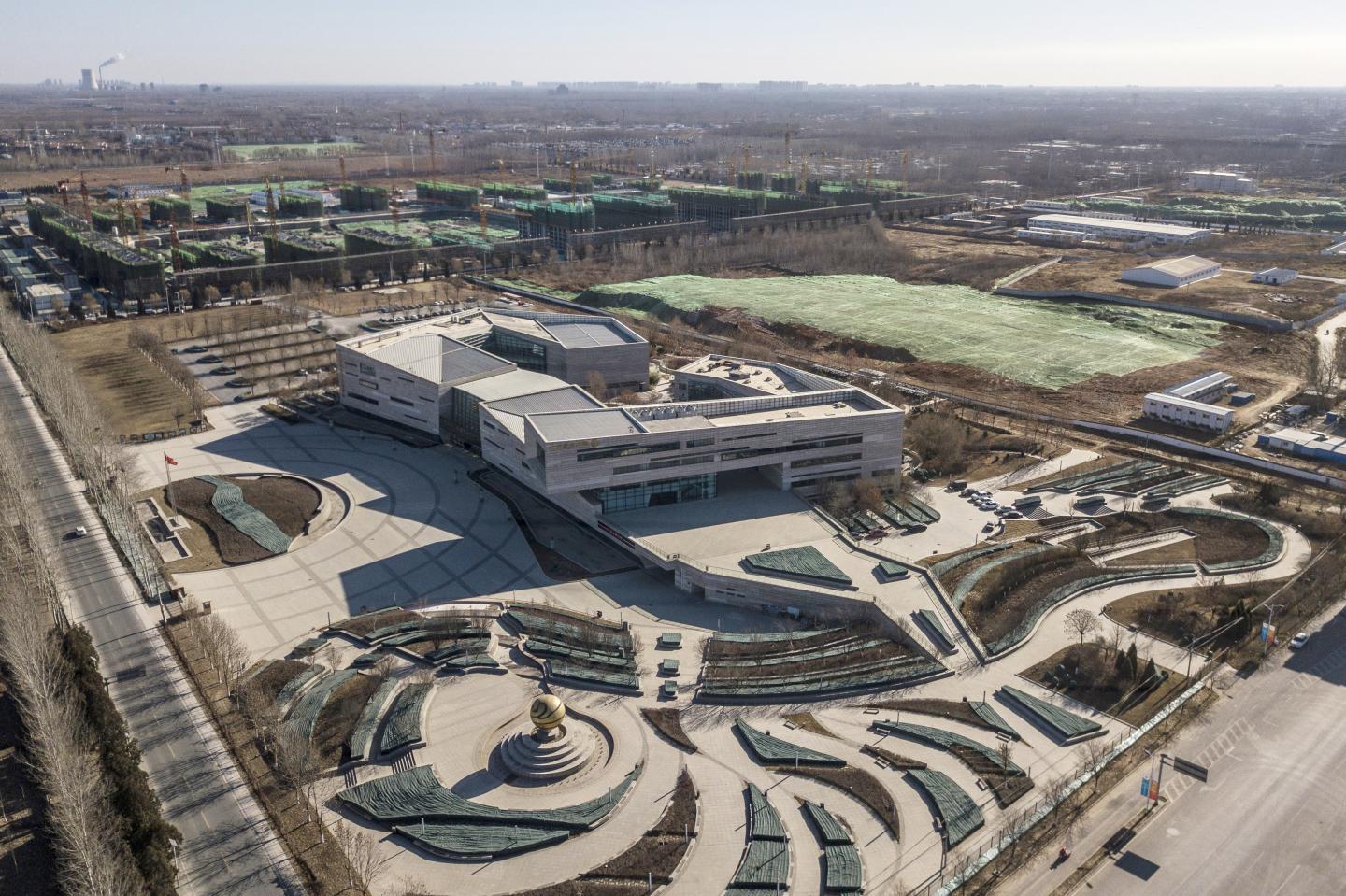 The Beijing Fund Town International Convention Center stands in front of buildings under construction in this aerial photograph taken over Beijing Fund Town outside of Beijing, China, on Tuesday, Dec. 11, 2018. The town was established by the government in 2015 to be a hub for the nation's $1.9 trillion private funds market. Photographer: Gilles Sabrie/Bloomberg via Getty Images