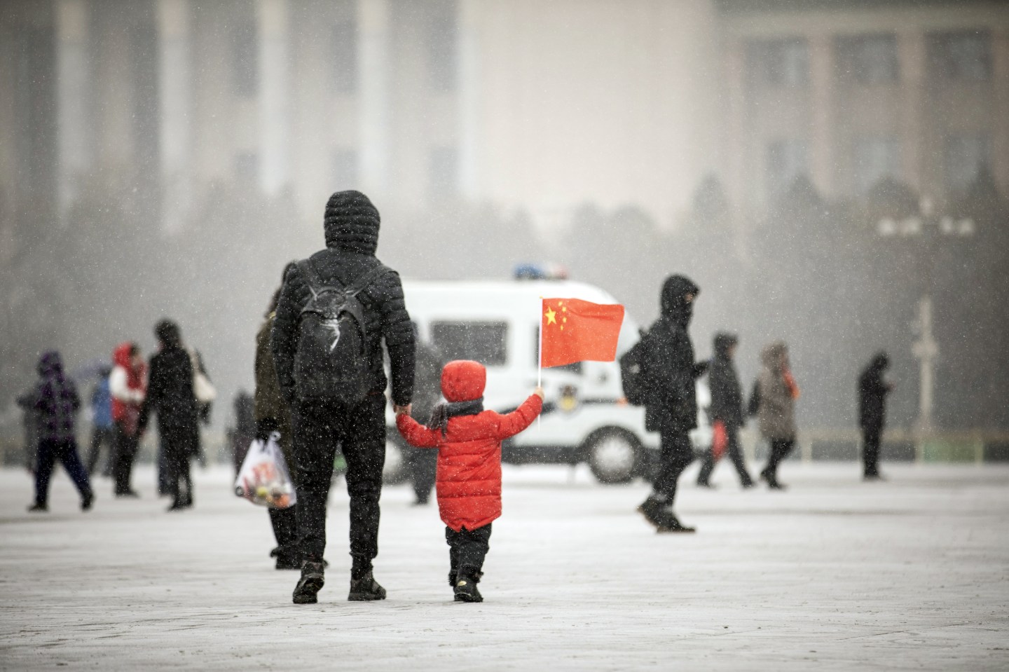 China child holds flag in Beijing snow