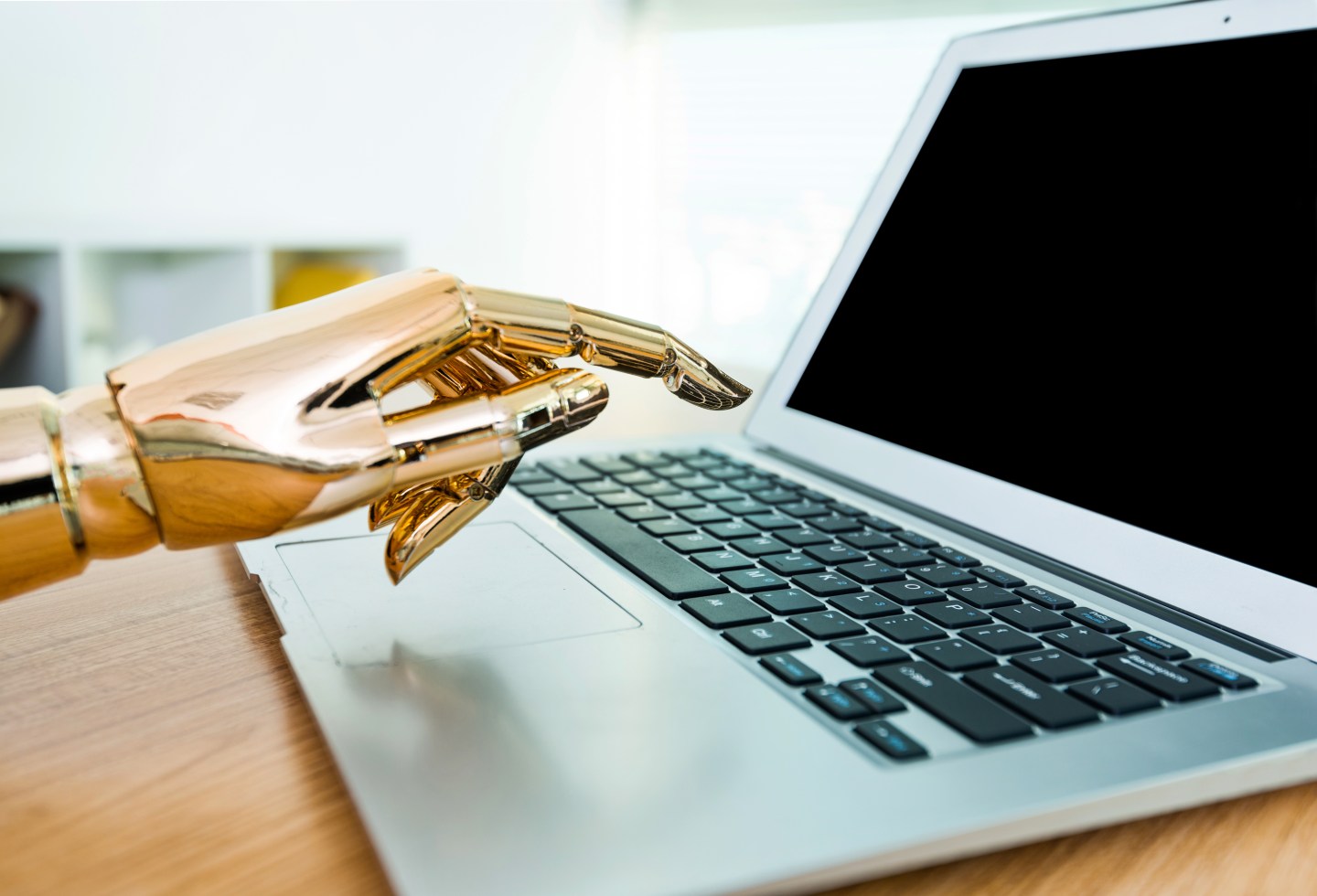 Robot's hand typing on keyboard.