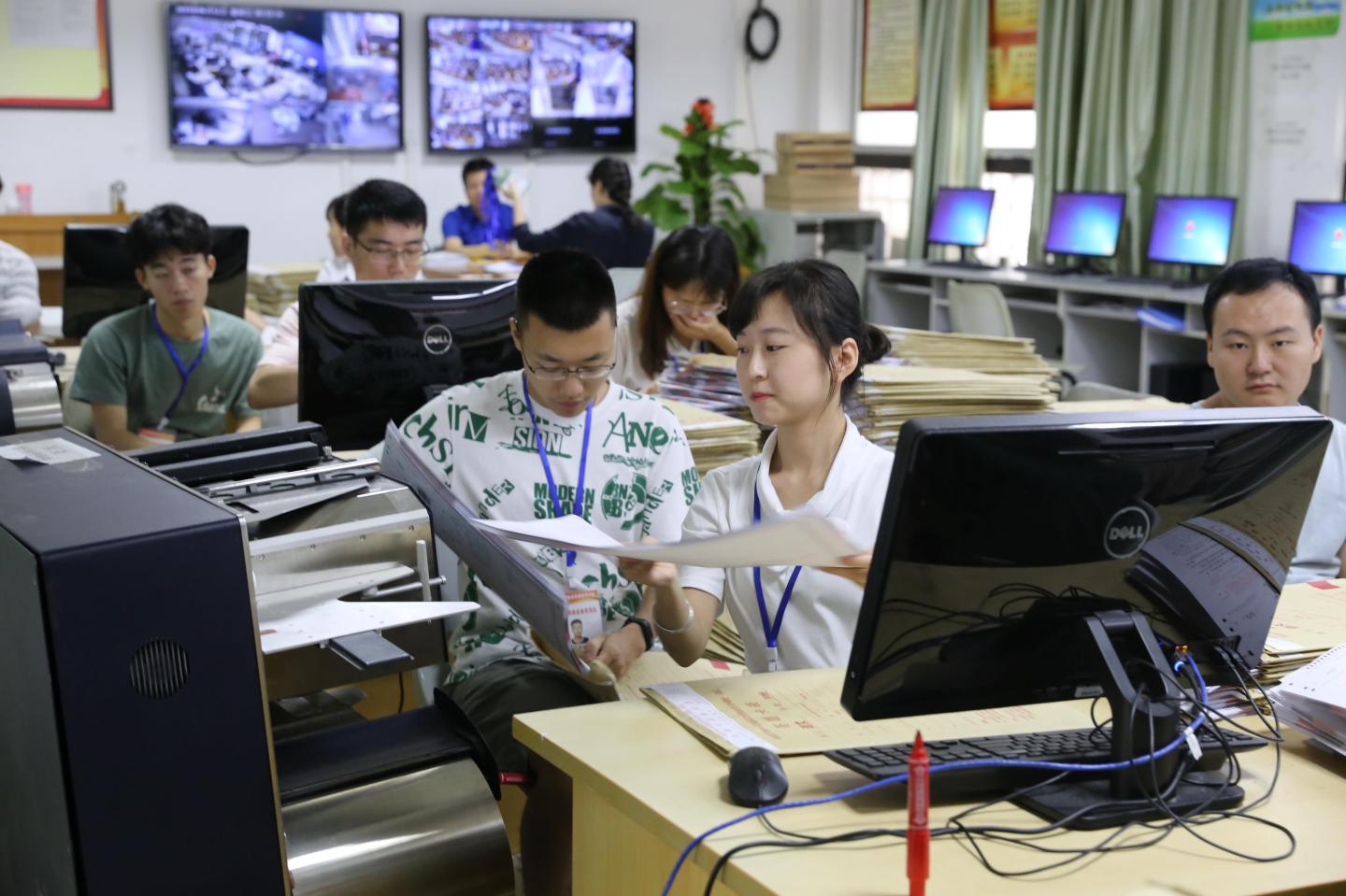 HAIKOU, CHINA - JUNE 12: Staff members scan exam papers into a computer for the 2019 National College Entrance Examination (aka Gaokao) at Hainan Normal University on June 12, 2019 in Haikou, Hainan Province of China. (Photo by Visual China Group via Getty Images/Visual China Group via Getty Images)