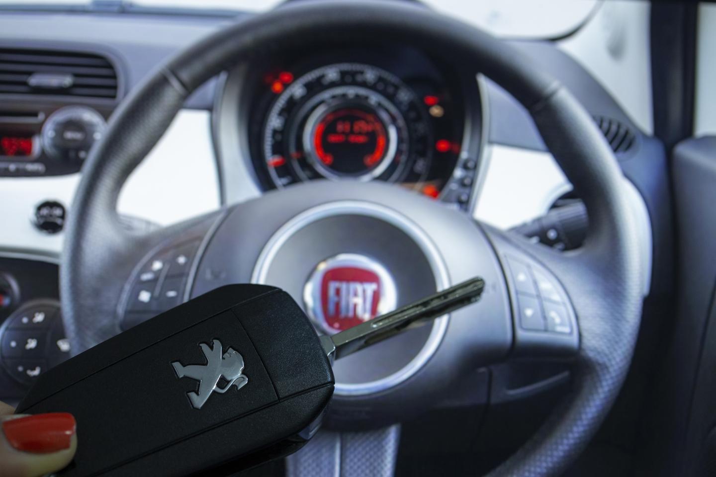 ANKARA, TURKEY - NOVEMBER 26: A woman holds a Peugeot car key as Fiat logo is seen behind in Ankara, Turkey on November 26, 2019. (Photo by Aytac Unal/Anadolu Agency/Getty Images)