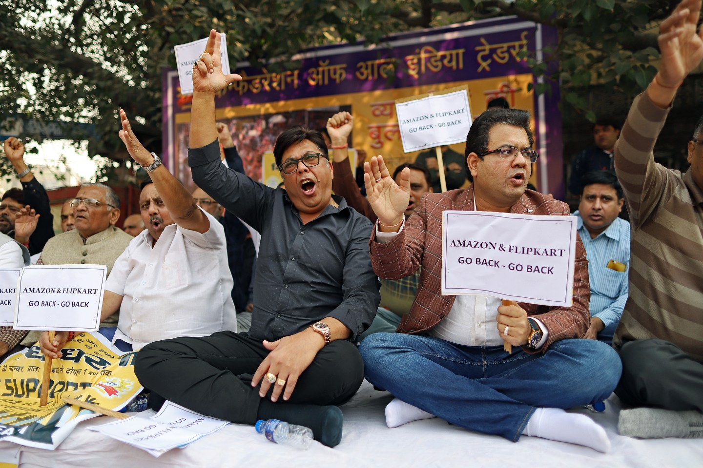Merchants display placards and shout slogans during a sit-in protest at Sadar Bazaar in New Delhi, India, on Wednesday, Nov. 20, 2019. In the heart of New Delhi's largest wholesale bazaar, merchants who normally compete with each other have united against a common enemy. The sit-in, which created more chaos than usual among the rickshaws, motorbikes and ox-carts plying the market road, was one of as many as 700 protests against Amazon.com Inc. and Walmart Inc. -- owner of local e-commerce leader Flipkart -- that organizers say took place at bazaars across India on a recent Wednesday. Photographer: Anindito Mukherjee/Bloomberg via Getty Images