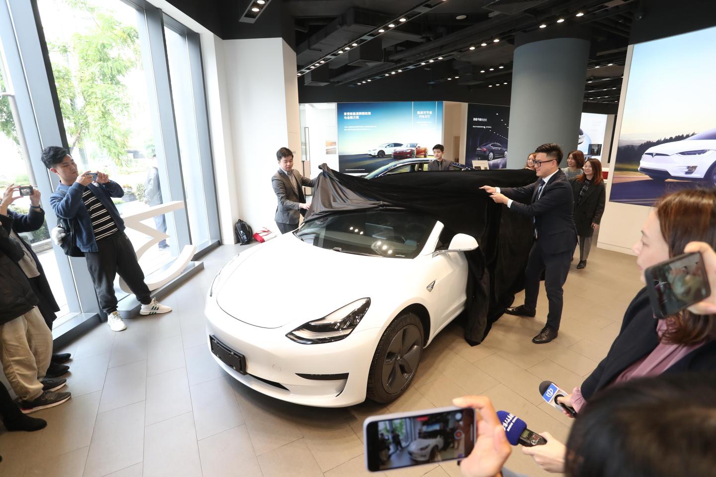 SHANGHAI, CHINA - NOVEMBER 22: People take photos of China-built Tesla Model 3 with its brand name in Chinese characters at a Tesla store on November 22, 2019 in Shanghai, China. China's homegrown Tesla Model 3 will be sold at a starting price of 355,800 yuan (about 50,560 US dollars). (Photo by Zhang Hengwei/China News Service/VCG via Getty Images)