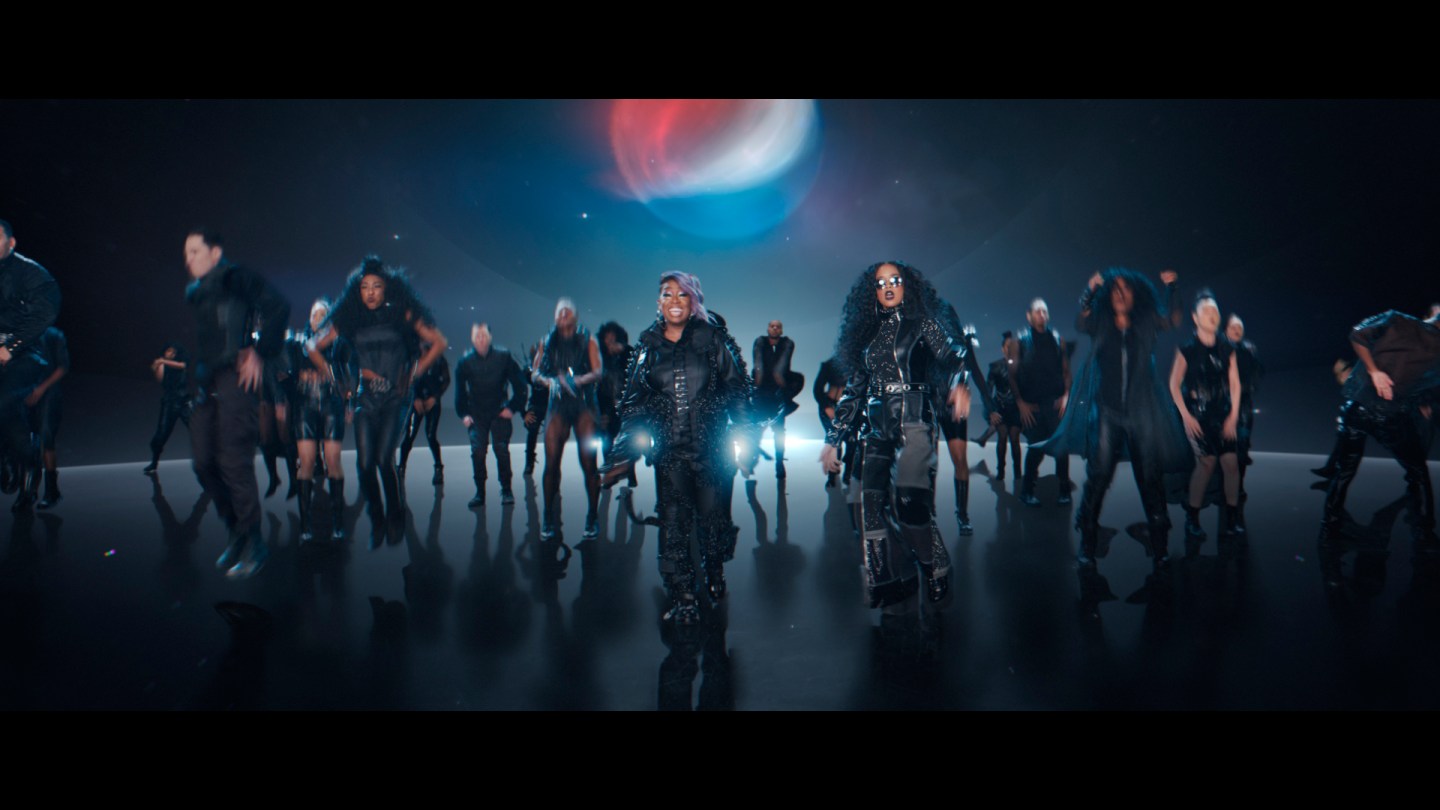 This undated image provided by PepsiCo shows Missy Elliott, center left, and H.E.R., center, right, in a scene from the company's 2020 Super Bowl NFL football spot. Pepsi tries to reignite the Cola Wars with Missy Elliott and H.E.R. performing an updated version of “Paint it Black” that starts with a red cola can that looks like a Coke changing into a black can of Pepsi Zero Sugar to the lyrics of “I see a red door and I want it painted black.” (PepsiCo via AP)