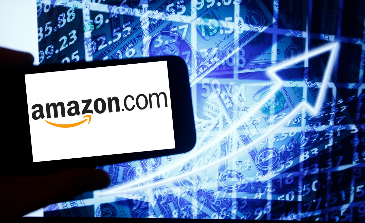 The logo of Amazon is seen on a screen of a smartphone next to a screen with an illustration of the stock market. The tech-heavy Nasdaq is beating all major U.S. indices this year, and is even outpacing gold. Wire photography: Alexander Pohl—NurPhoto via Getty Images