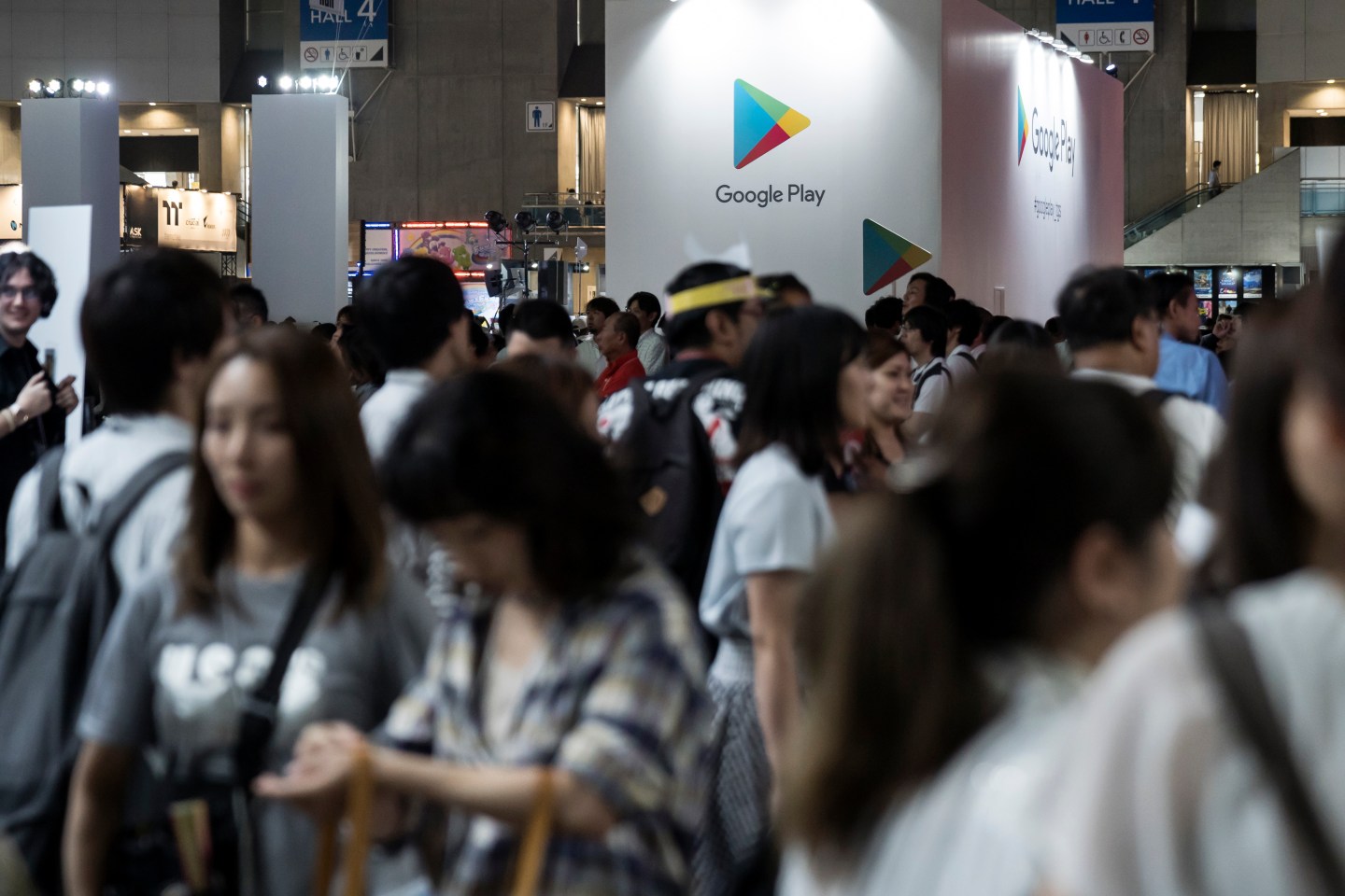 Conference attendees walk past a Google Play booth.