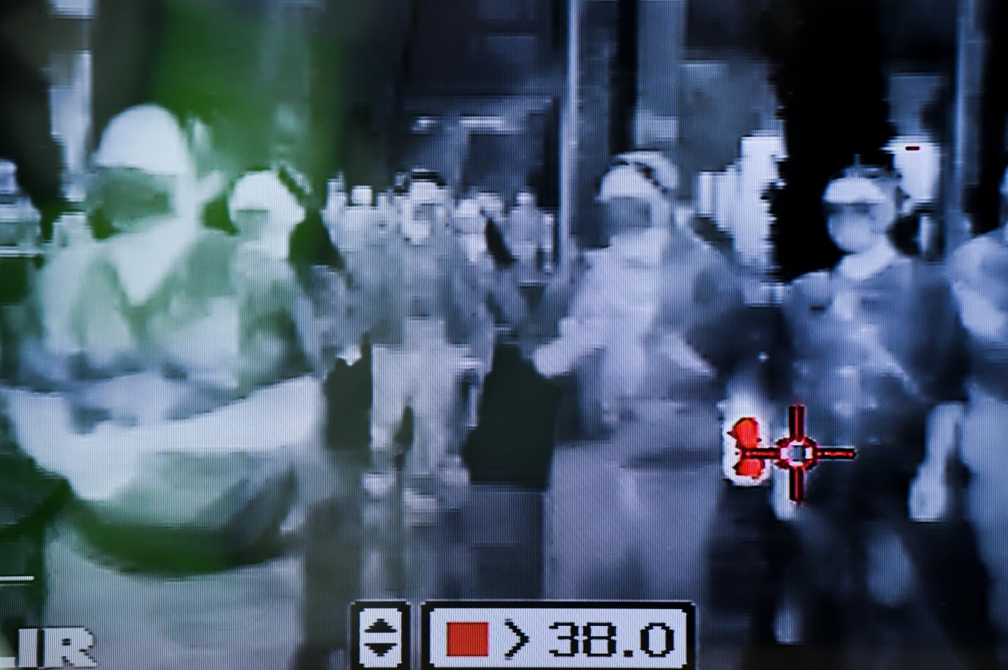 Security personnel use a thermal scanner to check people entering a department store in Bangkok, Thailand, 31 January 2020.